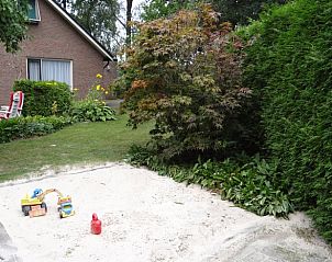 Zandbak met speelgoed in de tuin van vakantiehuis Hezingen, Twente, voor kinderen.