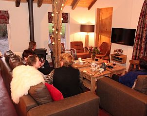 Groep vrienden ontspannen in de woonkamer van Huisje in Hezingen, vakantiehuis in Hezingen, Twente.