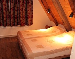 Sfeervolle slaapkamer met houten details in Huisje in Hezingen, vakantiehuis in Hezingen, Twente.