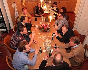 Gasten genieten van een maaltijd in de eetkamer van Huisje in Hezingen, vakantieaccommodatie in Twente, Overijssel.