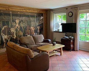 Comfortabele woonkamer in vakantiehuisje in Geesteren, met uitzicht op groene tuin in Twente, Overijssel.
