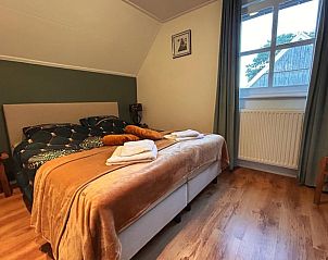 Slaapkamer met uitzicht op tuin in vakantiehuisje in Geesteren, rustieke charme in Twente, Overijssel.