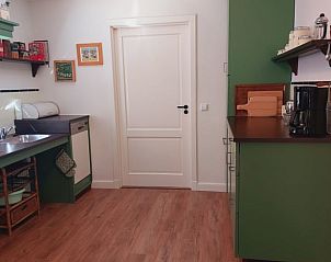 Ruime keuken in Vakantiehuis in De Pollen, Geesteren, met groene kastjes en houten vloer.