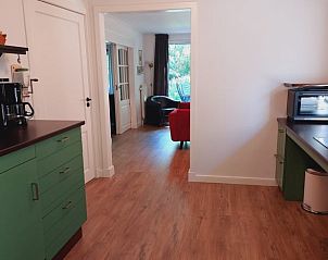 Open keuken en woonkamer in Vakantiehuis in De Pollen, Geesteren, met toegang tot terras.