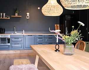 Gezellige keuken van Huisje in Reutum, vakantiehuis in Twente, Overijssel, met houten tafel en sfeervolle hanglampen.