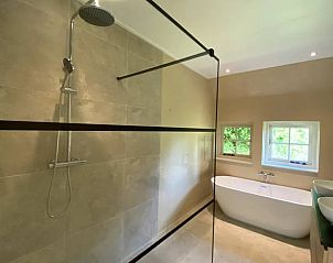 Luxe badkamer in Huisje in Reutum, vakantiehuis in Reutum, Twente, Overijssel met regendouche en vrijstaand bad voor ultiem comfort.