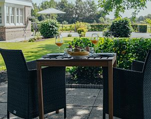 Ontbijt op het terras van Huisje in Rijssen, vakantiehuis in Twente, Overijssel, met uitzicht op de tuin.
