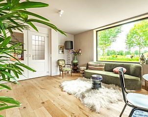 Stijlvolle woonkamer met grote ramen in Huisje in Rijssen, vakantieverblijf in Twente, Overijssel.