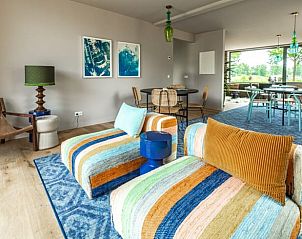 Lichte woonkamer met kleurrijke stoelen in Huisje in Rijssen, vakantieaccommodatie in Twente, Overijssel.