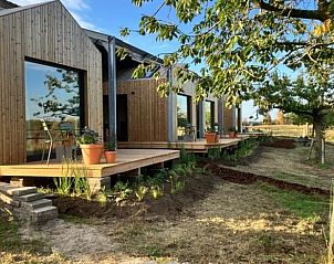 Vakantiehuisje in Rijssen met houten veranda in Twente, Overijssel, omgeven door natuur.