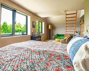 Sfeervolle slaapkamer in Huisje in Rijssen, Twente, Overijssel, met uitzicht op de groene omgeving en een gezellige zithoek.