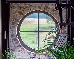 Rond raam met uitzicht in Vakantiehuisje in Ambt Delden, Twente.