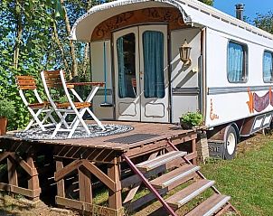 Charmant vakantiehuis in Hengelo, Twente met een uitnodigend terras en houten zitje.