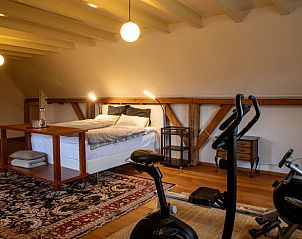 Slaapkamer met houten elementen en sportfaciliteiten in vakantiehuisje Hengelo, Twente, Overijssel.