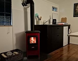 Gezellige binnenruimte met houtkachel in Vakantiehuisje in Hengelo(ov), ideaal voor knusse avonden in Twente, Overijssel.