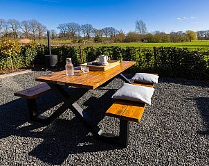 Buitenruimte van Vakantiehuisje in Hengelo met picknicktafel en uitzicht op groene velden in Twente.