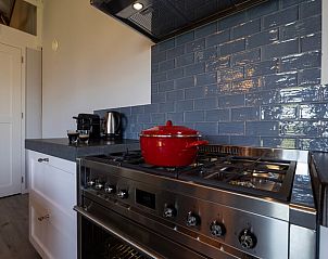 Moderne keuken in Vakantiehuisje in Hengelo met roestvrijstalen fornuis en stijlvolle tegels in Twente.