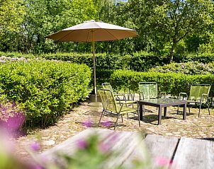 Zonnig terras met parasol bij Huisje in Haaksbergen, vakantiehuis in Overijssel.