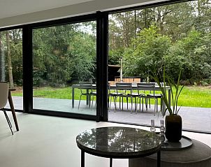 Uitzicht vanuit de woonkamer van Huisje in Haaksbergen, Twente, met terras en groene tuin.