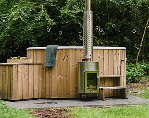 Houten hot tub in de tuin van Huisje in Haaksbergen, vakantiehuis in Twente, omringd door natuur.