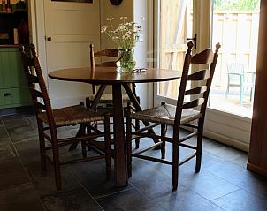 Cozy dining area in Holiday home in Haaksbergen, Twente with wooden table and chairs, enjoy the rustic charm in Overijssel.