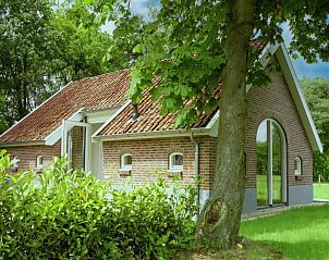 Charmante buitenkant van Design Lodge Twente in Haaksbergen, Overijssel, met bakstenen gevel en weelderige tuin.