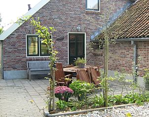 Charmant terras bij Vakantiehuis in Haaksbergen, Twente, Overijssel met houten tuinmeubilair.