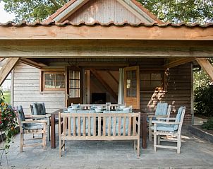 Gezellige veranda van Huisje in Diepenheim, vakantiehuis in Twente, Overijssel, omgeven door natuur met comfortabele zitgelegenheid.