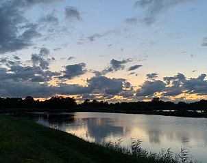 Betoverende zonsondergang bij Huisje in Diepenheim, vakantiehuis in Twente, Overijssel, met prachtig uitzicht op de serene natuur en water.