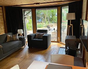 Lichte woonkamer van Vakantiehuis in Enschede met uitzicht op de tuin, gelegen in Twente, Overijssel.