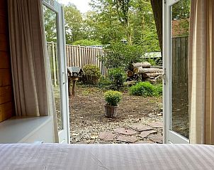 Uitzicht vanuit de slaapkamer van Vakantiehuis in Enschede op de serene tuin in Twente, Overijssel.