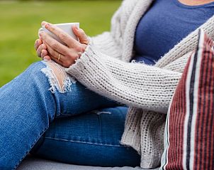 Ontspannen met een kopje koffie bij Huisje in Enschede, vakantiehuis in Twente, genietend van de serene tuin in Overijssel.