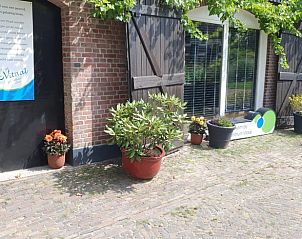 Buitenkant van Vakantiehuisje in Enschede, Twente, met bloempotten en landelijke uitstraling.