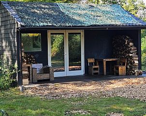 Charmant vakantiehuisje in Enschede met rustieke veranda en houtopslag, ideaal voor natuurliefhebbers in Twente, Overijssel.