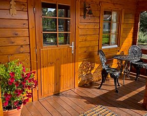 Gezellige veranda van Vakantiehuis in Enschede, Twente, met zitje en bloemen in Overijssel.