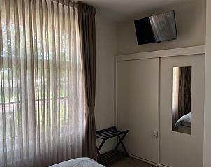 Slaapkamer met televisie in Vakantiehuisje in Enschede, ideaal voor ontspanning.