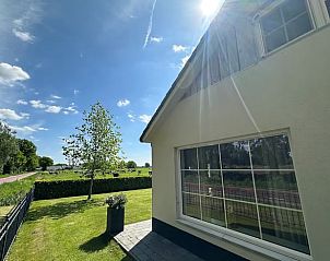 Zonnige dag bij Vakantiehuisje in Enschede, met uitzicht op de groene omgeving.
