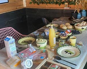 Ontbijttafel in de buitenruimte van Huisje in Enschede, vakantiehuis in Overijssel.