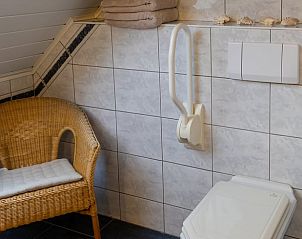 Comfortabele badkamer met rieten stoel in Huisje in Oldenzaal vakantiehuis in Twente, Overijssel.