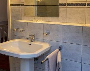 Wastafel met spiegel in moderne badkamer van Huisje in Oldenzaal vakantiehuis in Twente, Overijssel.