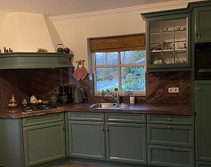 Stijlvolle keuken in Huisje in Oldenzaal vakantiehuis in Twente, Overijssel met groene kasten.