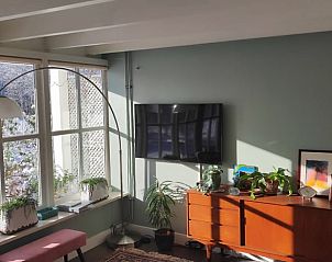 Stijlvolle zithoek met televisie in Huisje in Oldenzaal, perfect voor ontspanning.