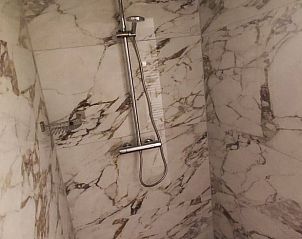 Stijlvolle douche in Huisje in Oldenzaal, Twente, met marmeren tegels en moderne uitstraling.