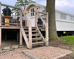 Raised terrace at cottage in Markelo, Twente, Overijssel with wooden stairs and views of green nature.