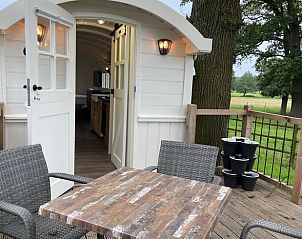 Outdoor terrace of Holiday Home in Markelo, Twente, Overijssel with wooden table and chairs for relaxation.