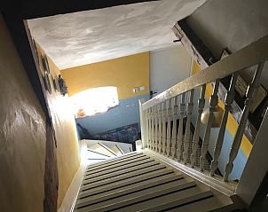 Trap in Vakantiehuisje in Markelo, een charmante vakantiewoning in Twente, Overijssel, met authentieke details en warme kleuren.