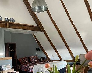 Gezellige binnenruimte van Vakantiehuisje in Markelo, Twente, met houten balken en comfortabele zithoek in Overijssel.