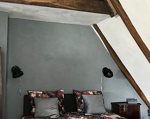 Sfeervolle slaapkamer in Vakantiehuisje in Markelo, Twente met rustieke houten balken en comfortabele bedden, perfect voor een ontspannen verblijf.