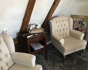 Gezellige zithoek in Vakantiehuisje in Markelo, Twente. Comfortabele stoelen en houten details creren een warme sfeer in deze vakantiewoning in Overijssel.