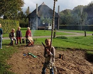 Kinderen spelen buiten bij Vakantiehuisje in Enter, Twente, Overijssel met kampvuur en natuur.